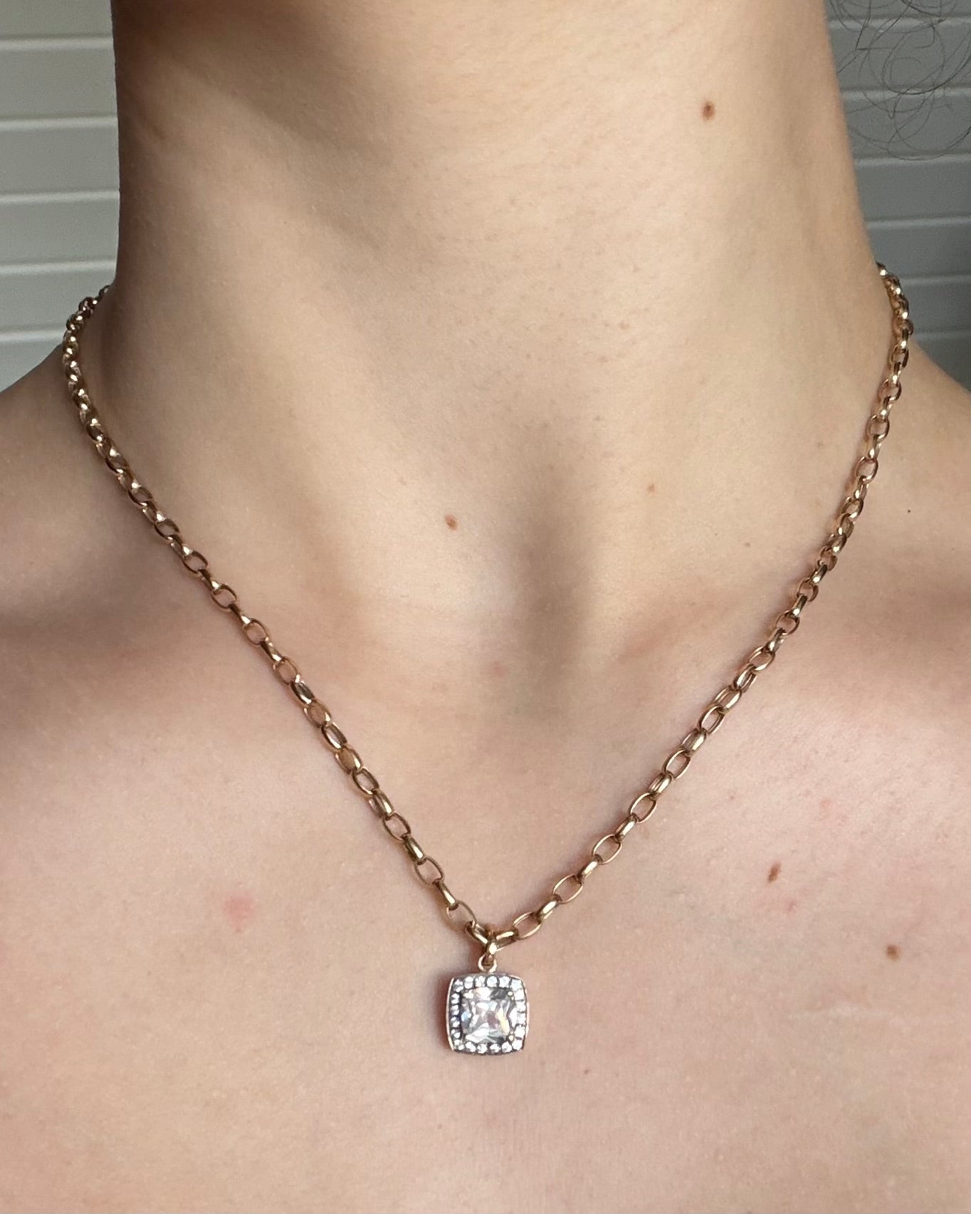 Vintage 9 karat guldhalskæde og vedhæng med cushion-cut sten samt halo-effekt
